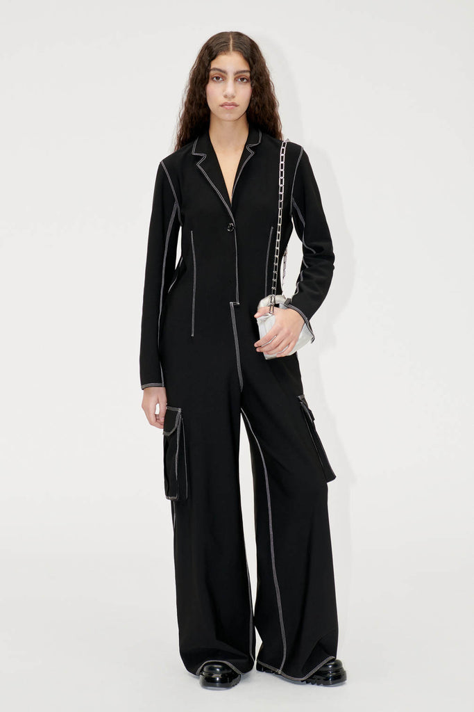 black loose slouchy cargo jumpsuit all in one by Stine Goya with white contrast stitching and side pockets