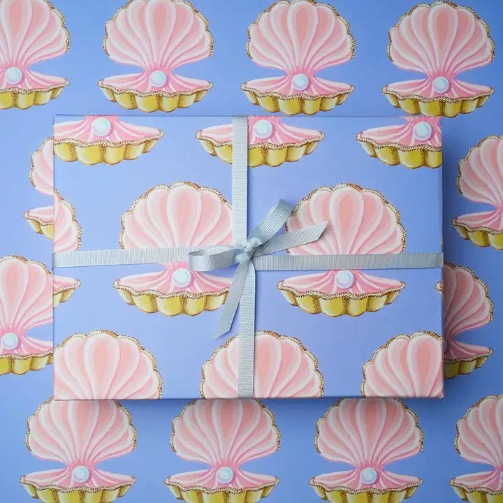 blue wrapping paper with pink oyster shells with a pearl inside